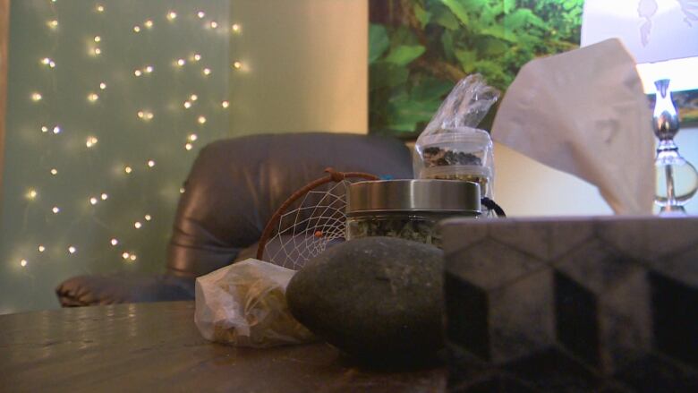 A tissue box sits on a table next to a stone and a dream catcher.