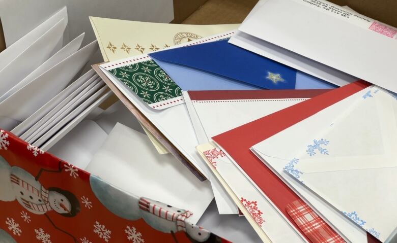 A stack of mail sits on a desk.