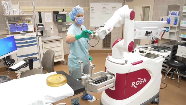 Nurse wearing her scrubs touches red and white technology.