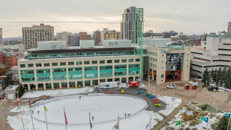 A city hall with a skating rink in front of it at the end of autumn,