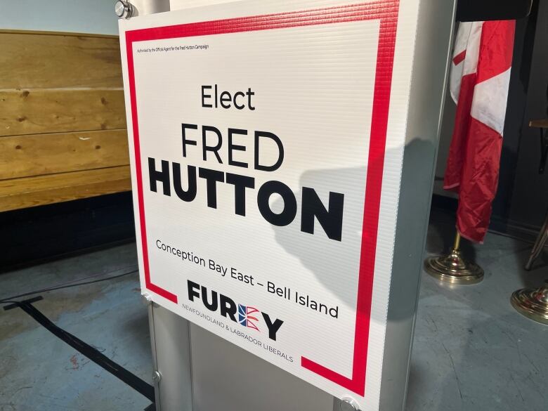 A white sign with a red border reads 'Elect Fred Hutton'. 