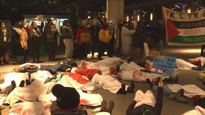 A group of people under white sheets laying down.