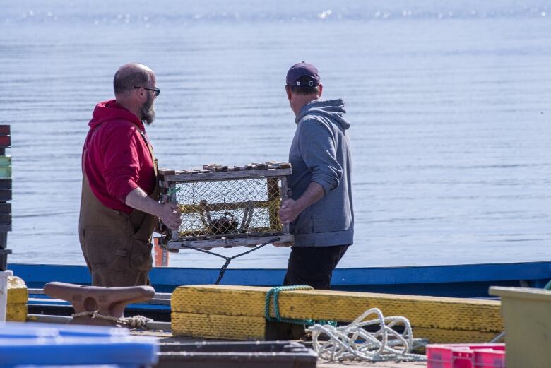 A trap is loaded onto a boat as it gets ready to head back out with the last of the 150 traps in the second load. 