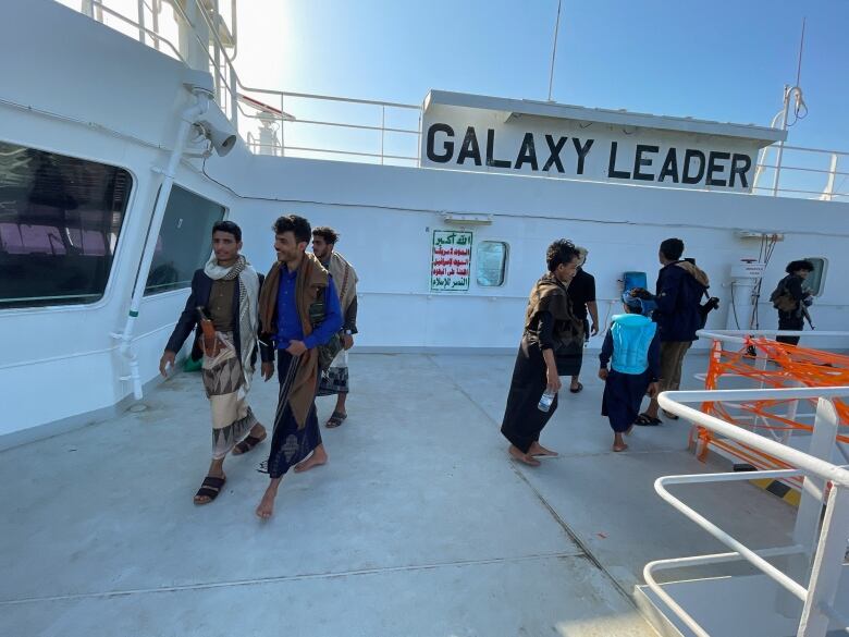 People tour the deck of the Galaxy Leader commercial ship, seized by Yemen's Houthis last month, off the coast of al-Salif, Yemen December 5, 2023. 