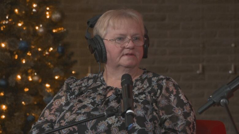 Woman with short blonde hair wearing headphones.