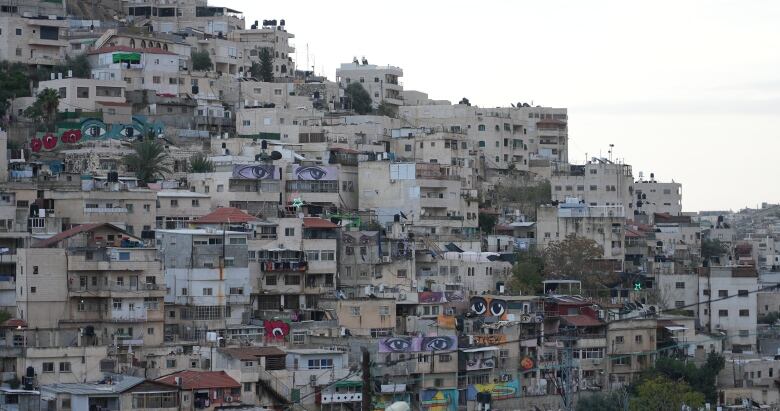 Buildings built on a hillside appear to be stacked on top of each other.