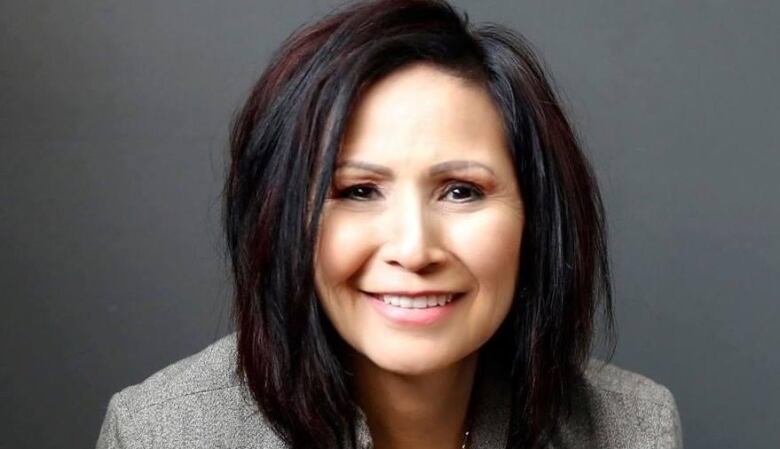 A woman smiles for a close-up headshot.