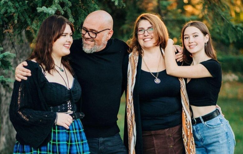 A family of four standing outside