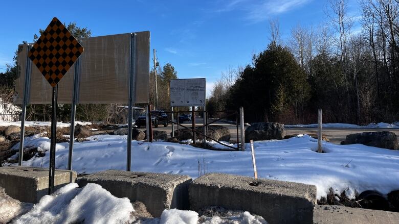 cinder blocks and a ditch delineate a the us-canada border at roxham road. snow covers the ground 