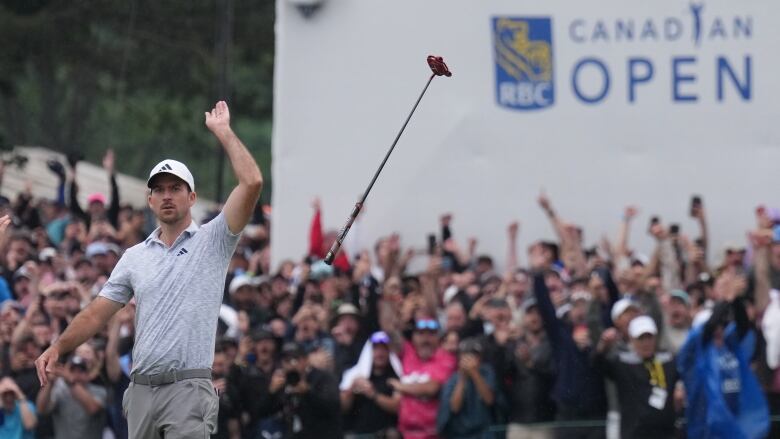 A golfer throws his putter in the air.