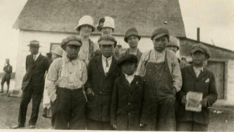 Black and white photo shows a group of children posing for the camera