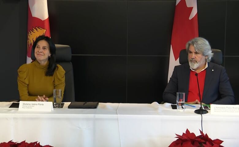 mayor plante sits at a table with pablo rodriguez during a press conference 