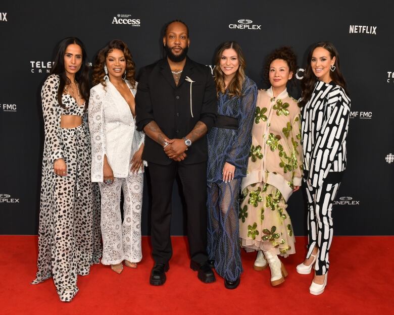 a group of people all well dresses posing for the camera.