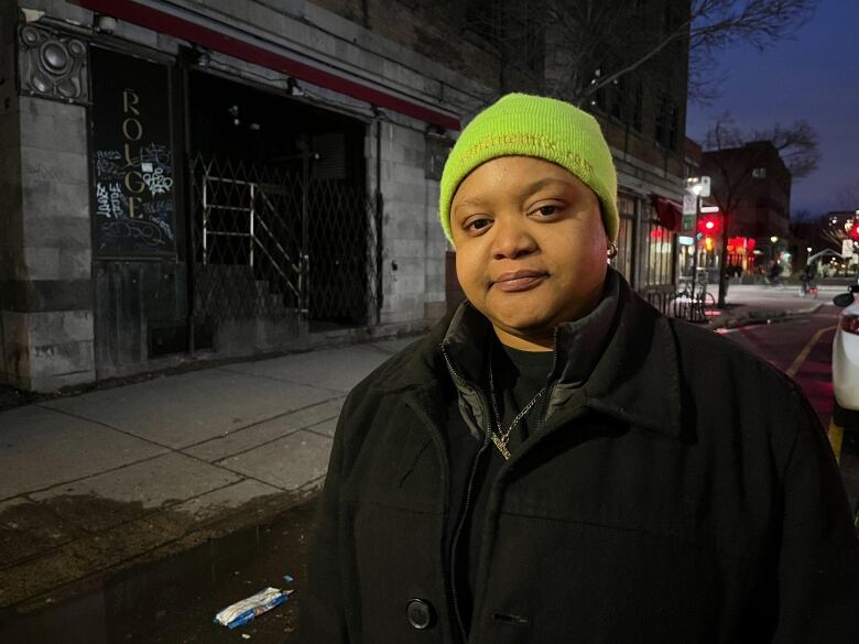 a Black woman wearing a green tuque and black jacket