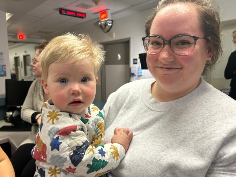 A woman holding her baby in a hospital. 