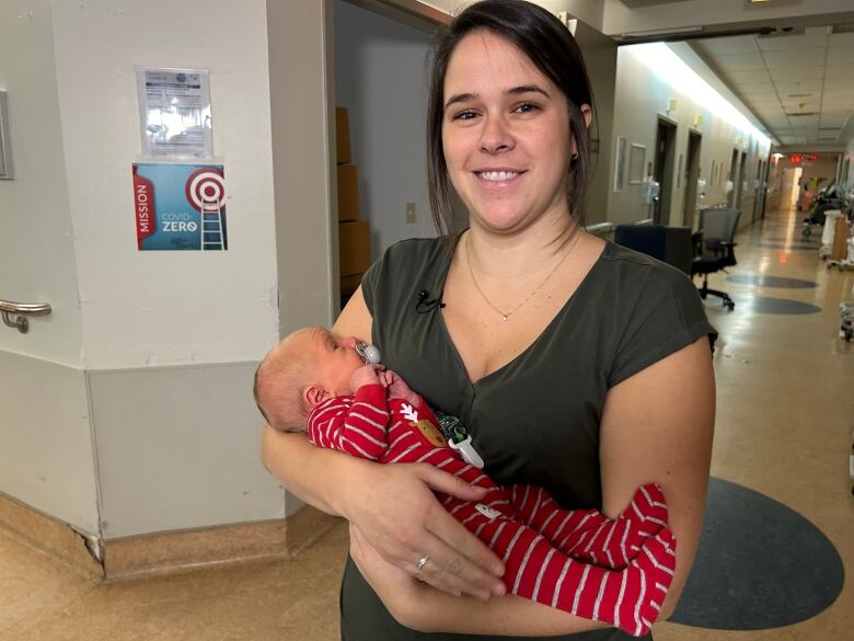 A woman holding her infant in a hospital. 