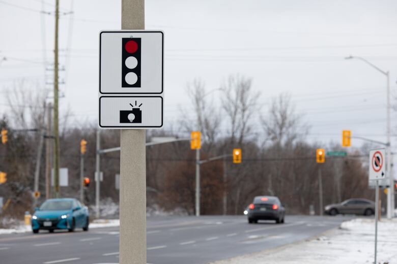 A sign on a road warning of a red light camera.