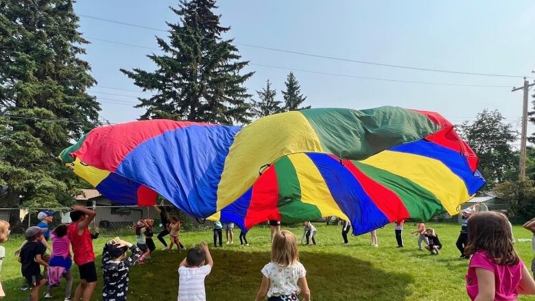 A parachute game at Les Petits Soleils Inc. French KinderCare in Sherwood Park, Alta. 