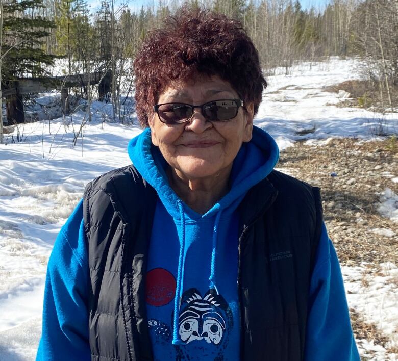 Woman standing outside and smiling at the camera.