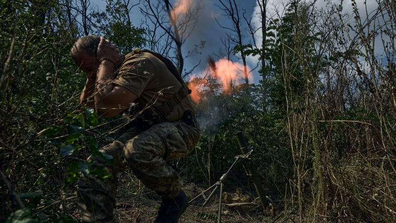 A soldier fires a mortar.