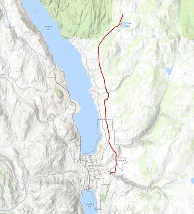 A red pipeline, starting from east of Penticton, B.C., goes upwards towards Chute Lake in the Okanagan.