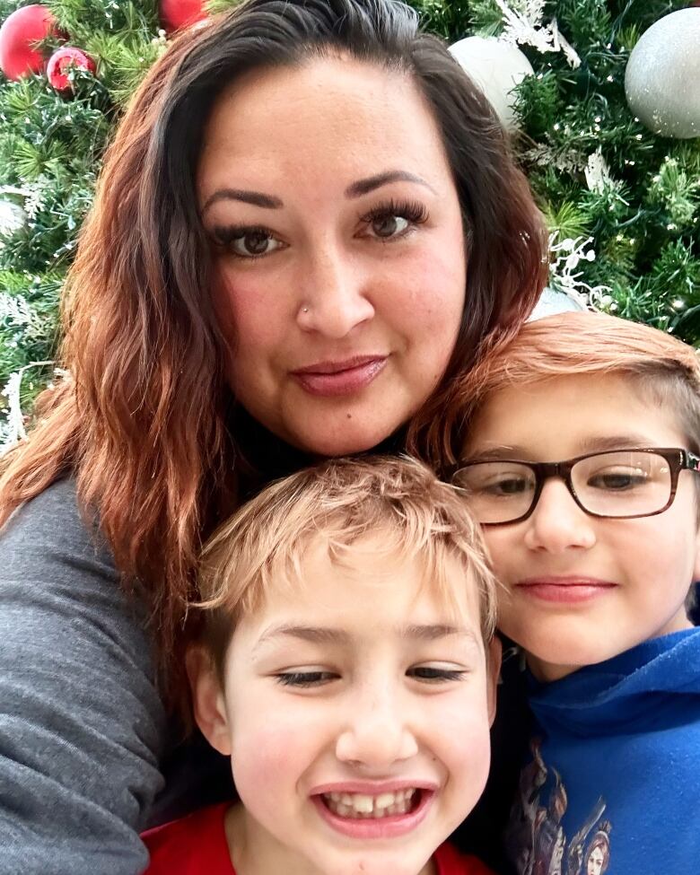 A mother and two boys pose for a photo.