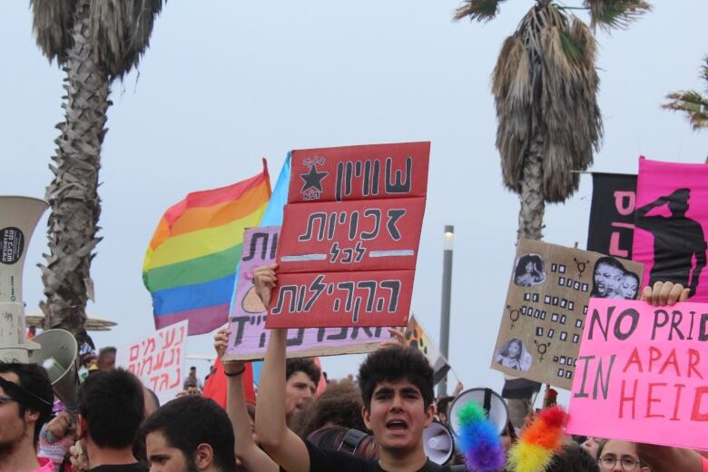 A crowd of protesters holding signs. 