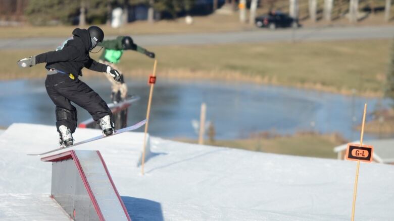 Two snowboarders on a terrain park