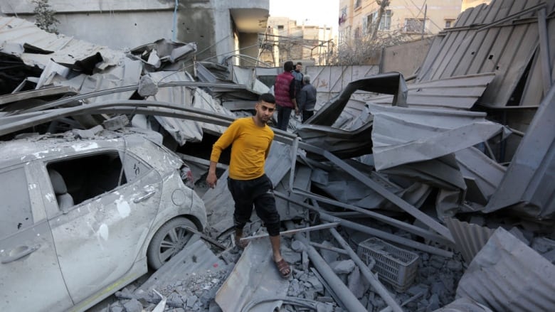 A man walks on rubble left from an airstrike.