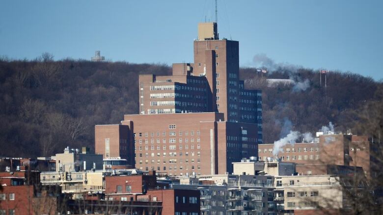 A buildings stands in front of a mountain.