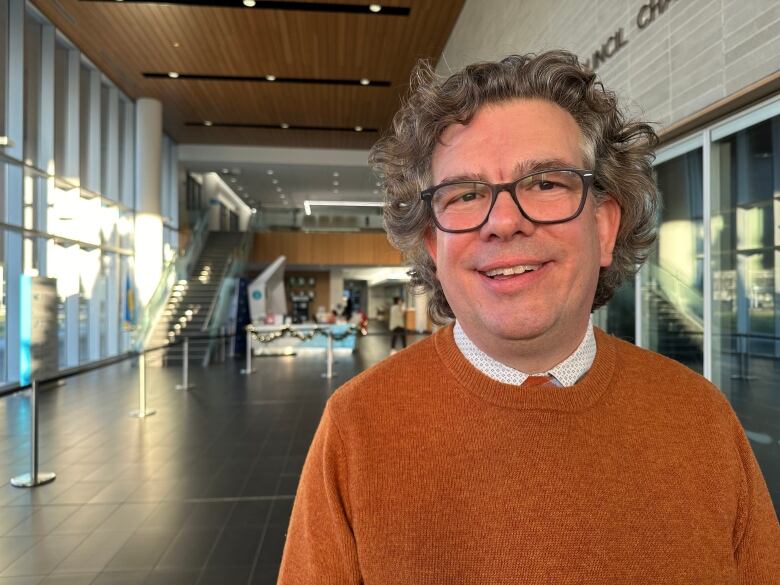 A man stands smiling inside of Windsor's city hall.