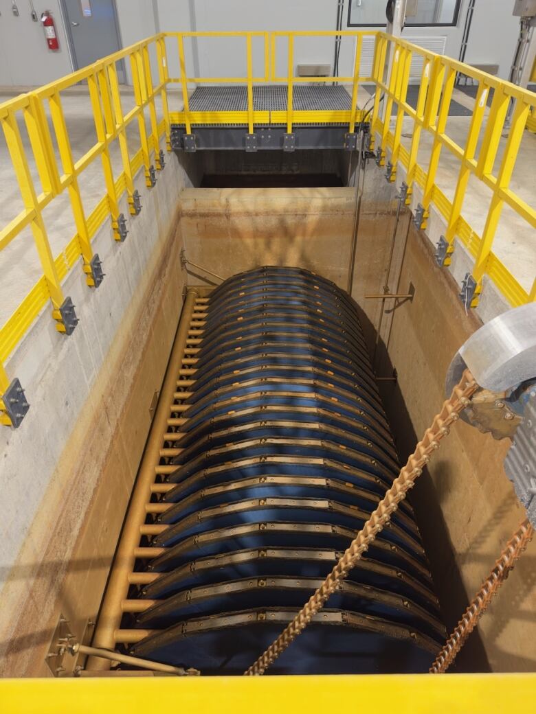 A row of blue disks arranged in a column in a concrete tank. 