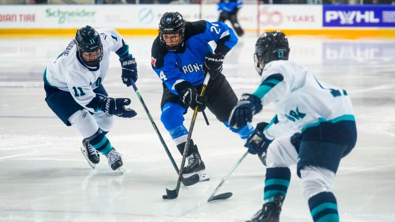 Two female ice hockey players battle for the puck during a game.