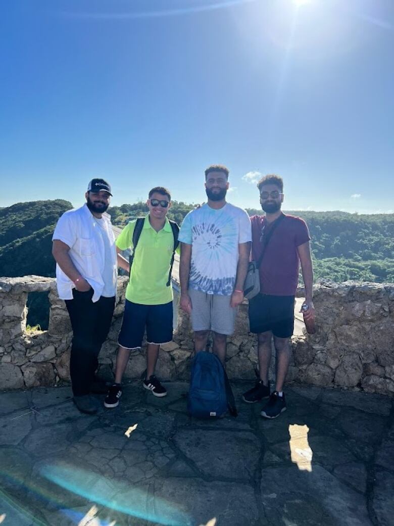 Four men pose for a photo on a sunny day in Cuba.