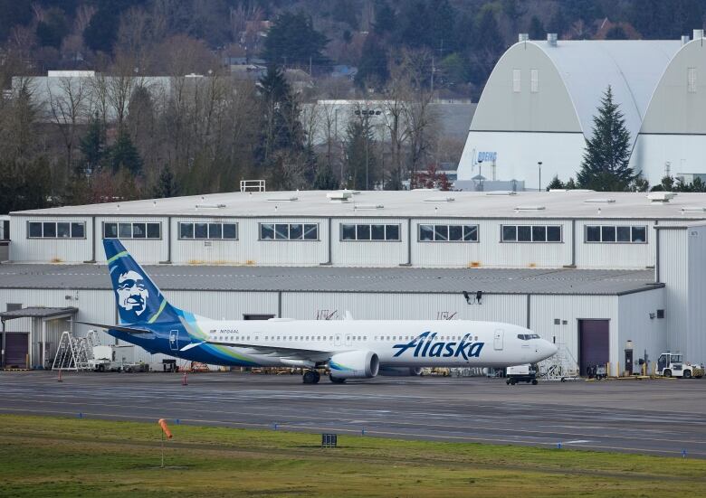 Alaska Airlines N704AL, a 737 Max 9 which made an emergency landing at Portland International Airport, is seen parked at an airport maintenance hangar.