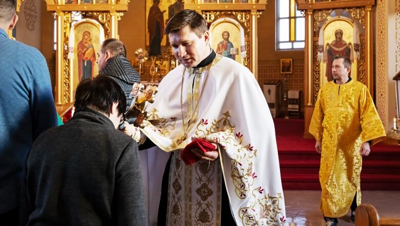 Church blessing passed down from priest to parishioner. 