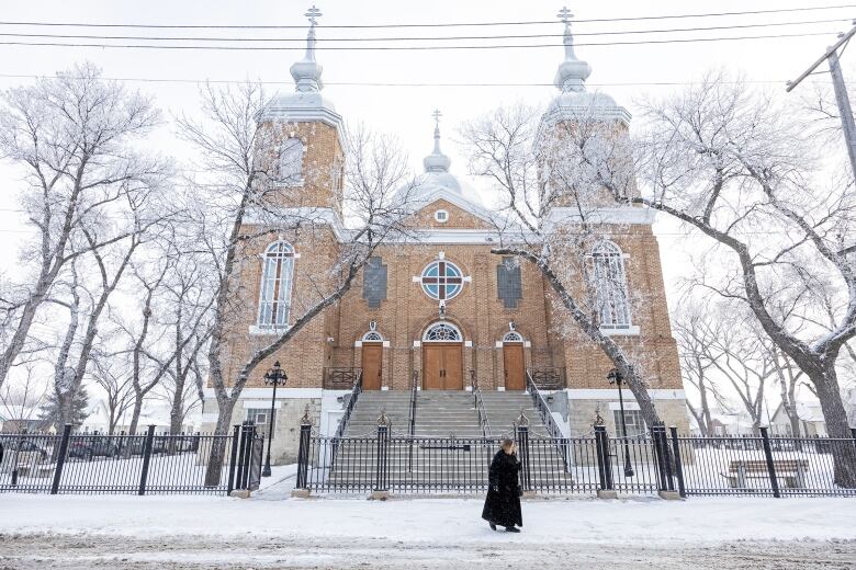 An old church stands behind a sidewalk.