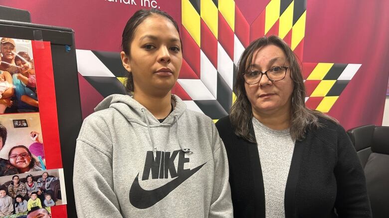 Two women stand in a room.