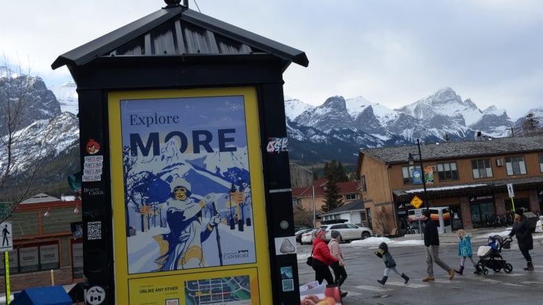  See people crossing street, snow-caped mountains in bg.