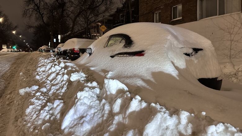 A car almost completely covered in heavy snow. 