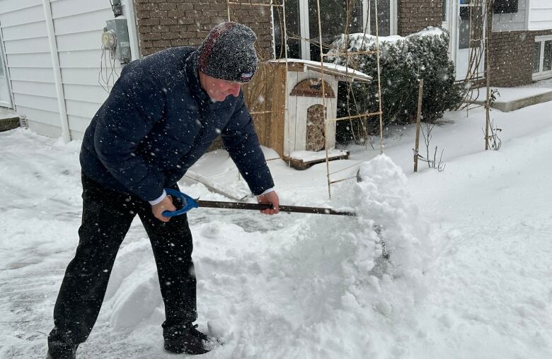 A man shovelling his driveway