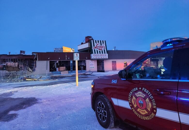 a fire truck parked outside a building that has severe damage