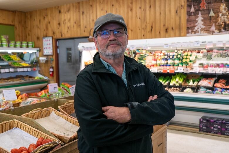 A man stands in a grocery store. 