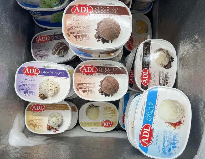 A freezer with cartons of ADL ice cream.