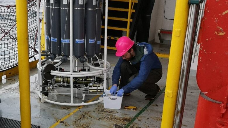 A man does scientific measurements on board a ship.