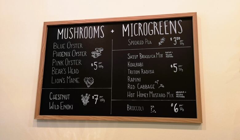 A blackboard lists a variety of mushrooms and microgreens for sale.