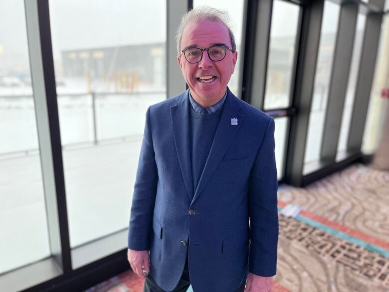 Philip Brown stands in a lobby with windows behind him overlooking a parking lot