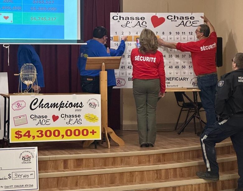 A giant calendar with three people standing around it.