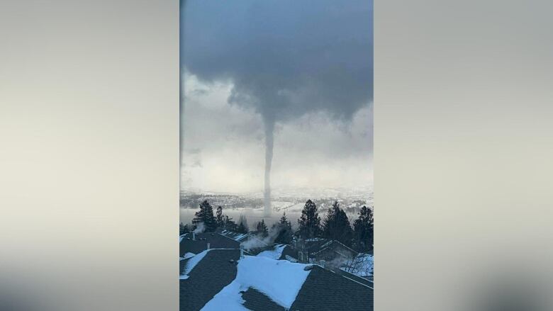 What looks to be a tornado over a lake.