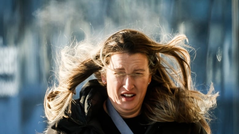 A woman runs in from the cold trailing a steam cloud.